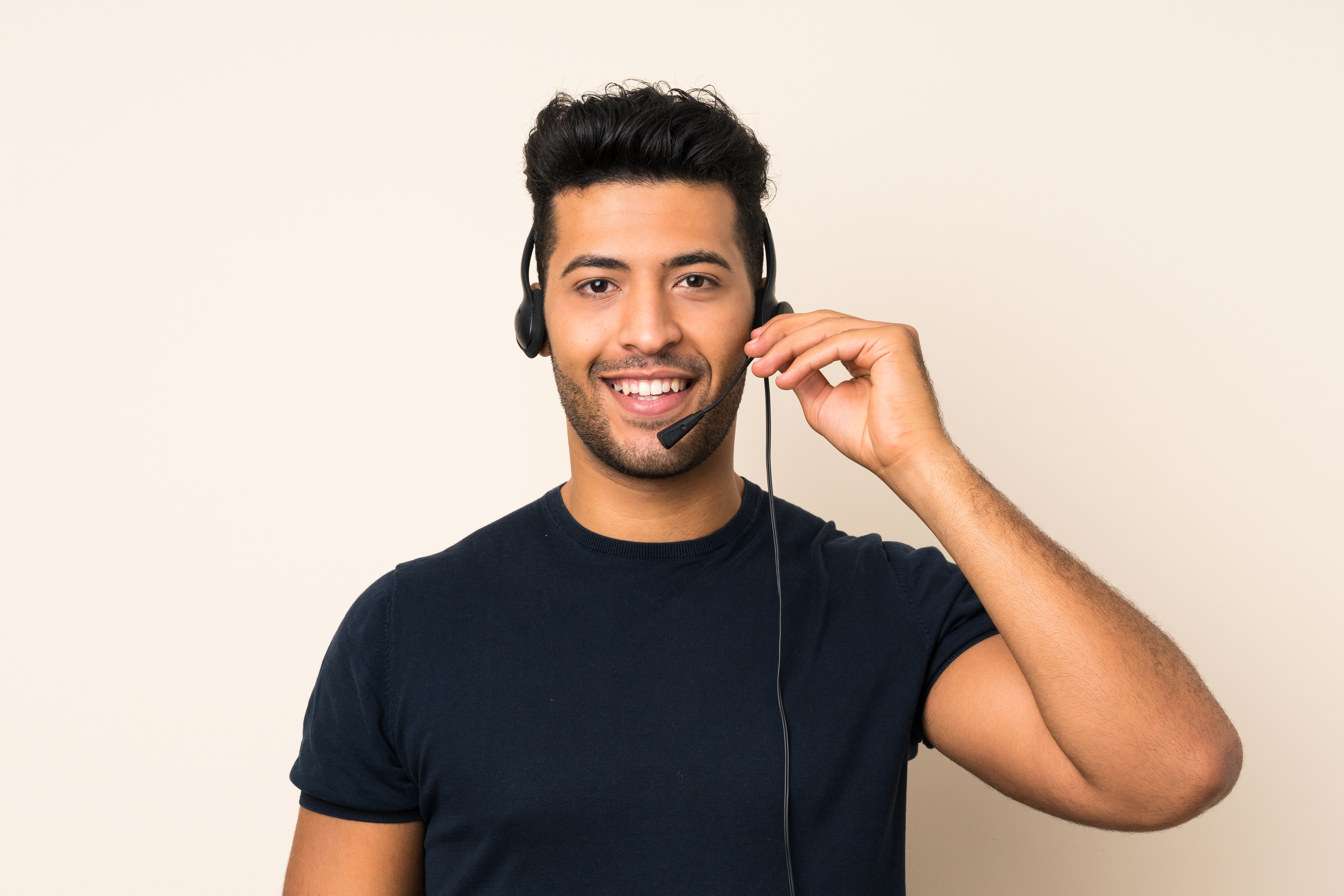 Young handsome man over isolated background working with headset